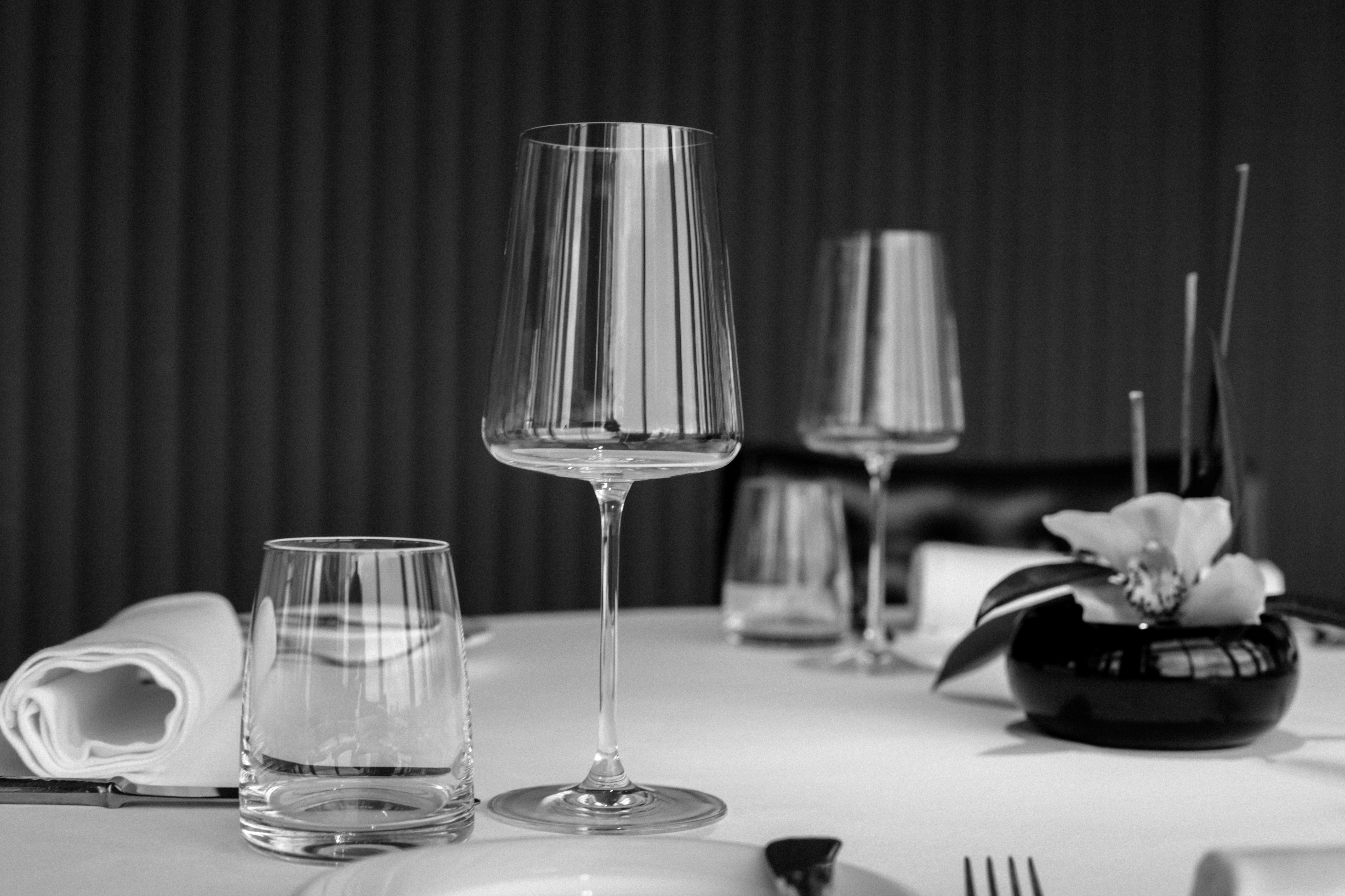 grayscale photo of drinking glass on table